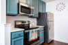 Kitchen with modern appliances and aqua colored cabinets and draws.