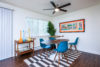 Dinning room with round table and four blue chairs kitchen entrance adjacent.