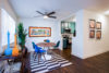 Dinning room with round table and four blue chairs kitchen entrance with stove and microwave.